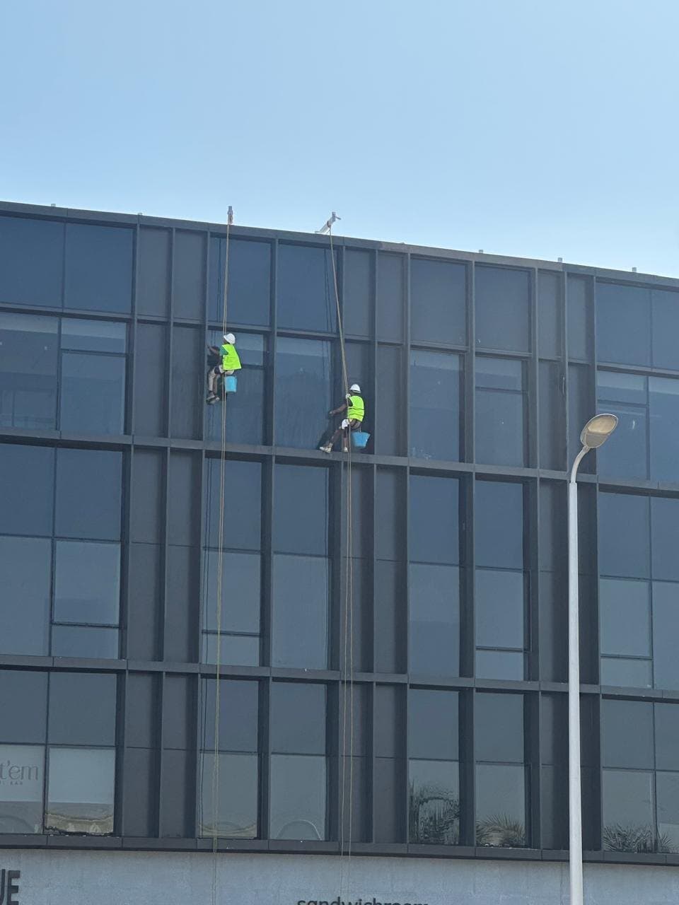 Two rope-access technicians on a façade